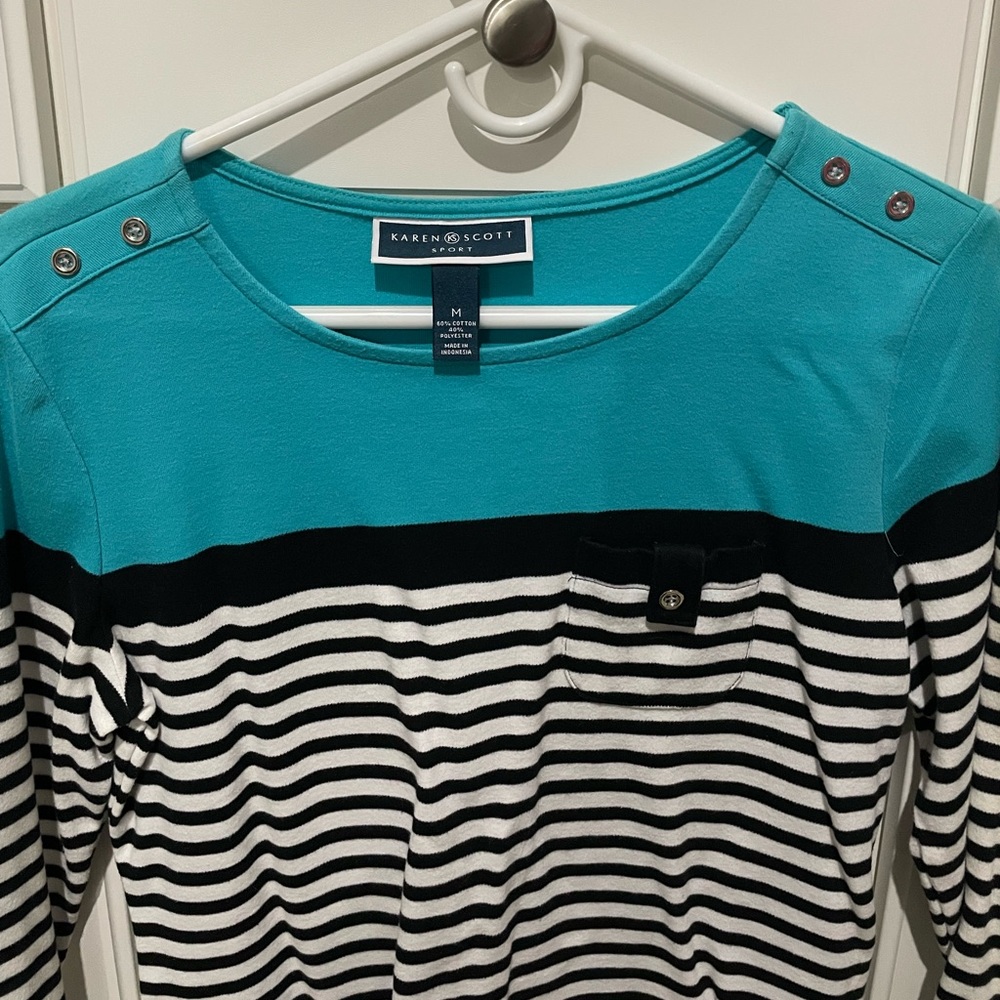 Women’s medium three-quarter length top. Pocket on front with button.